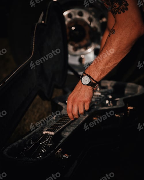 Preview: Vertical shot of a musician's hands getting his electric guitar out of the case