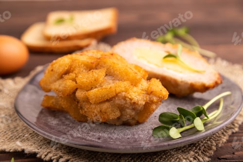 Preview: Chicken Schnitzel on gray plate with microgreen on brown wooden background and linen textile.