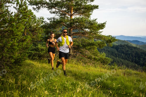 Preview: Couple trail running in a scenic mountain landscape with lush greenery and clear skies.