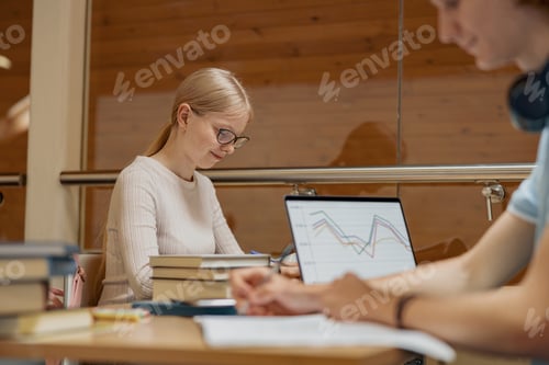 Preview: Two friends students with laptop and books studying in University Library
