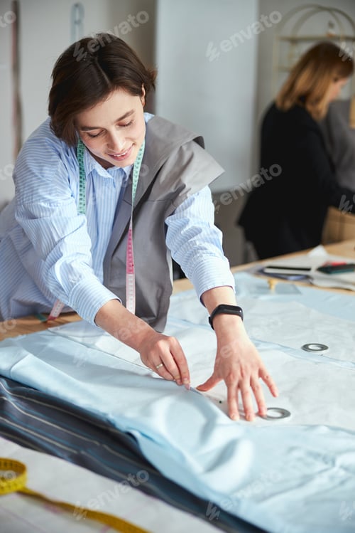 Preview: Optimistic dress designer laying out dress form with chalk