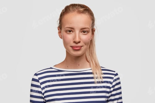 Preview: Close up portrait of attractive female has no make up, healthy skin, wears casual outfit, looks dire