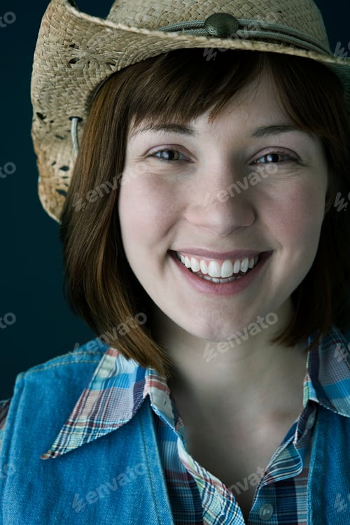 Preview: Smiling woman in a cowboy hat and plaid shirt