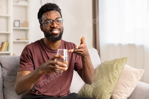 Preview: Smiling Man Holding Glass of Water Pointing at Camera