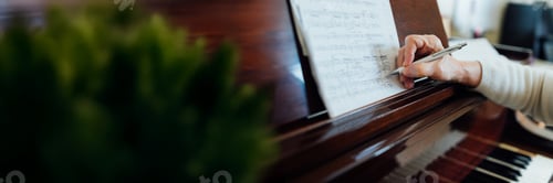 Preview: Wide banner of musician annotating sheet music