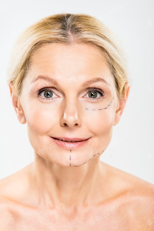 Preview: beautiful and middle aged woman with lines on face looking at camera on grey background