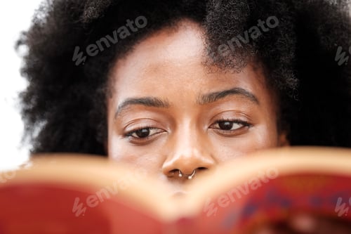 Preview: Close-up of black woman reading book.