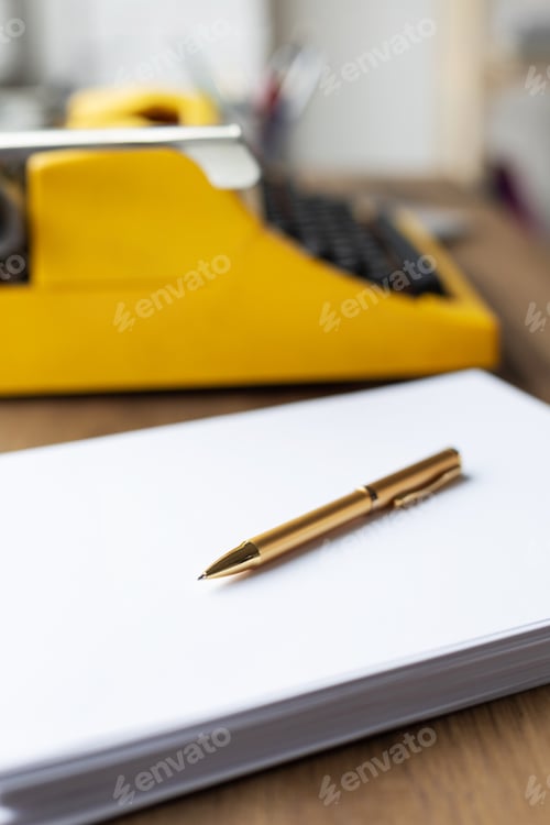 Preview: Pen on stack of paper and vintage old typewriter at wood desk table. Writer or study creative