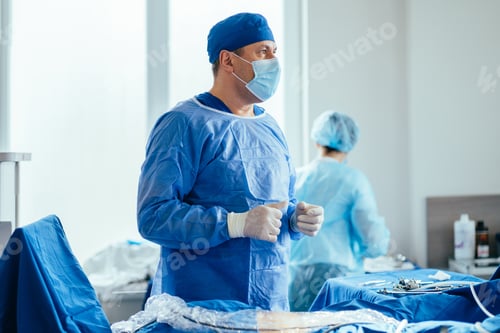 Preview: Gynecology. Close up of thoughtful male surgeon portrait in light operating room.