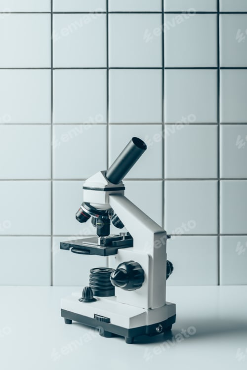 Preview: optical microscope on white tablet in front of tiled wall