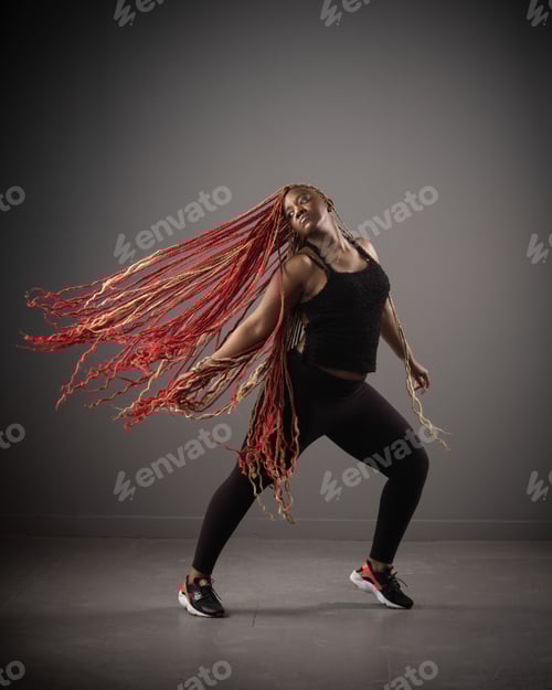 Preview: African American female in a black outfit and red braids joyfully dancing with flying hair