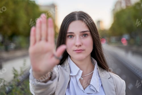 Preview: Young woman wearing business style doing stop sing with palm of the hand. warning expression