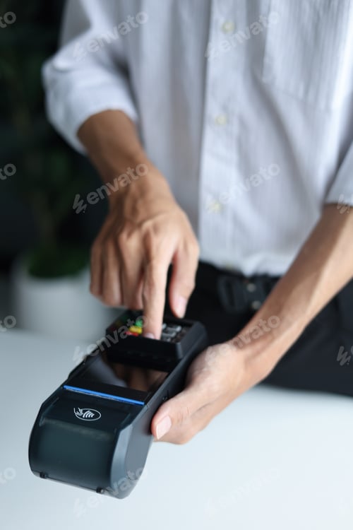 Preview: A person using a point-of-sale (POS) terminal to process a transaction.