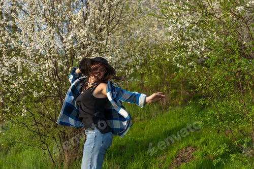 Preview: The girl is jumping near the flowering trees.