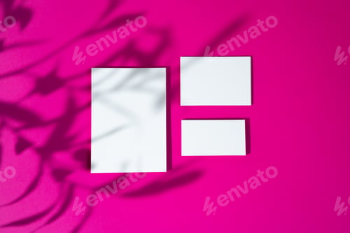 Preview: Advertising mock-up. White blank businesscards on bright pink background