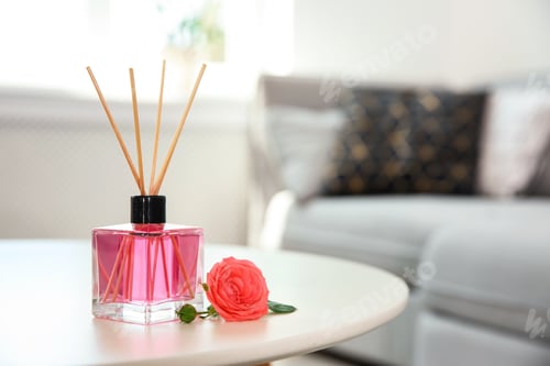 Preview: Aromatic reed air freshener and rose on table indoors