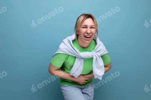 Preview: blond cheerful bright girl in a casual outfit laughing widely until her stomach hurts on a blue