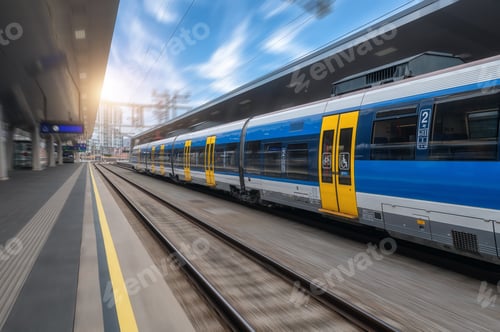 Preview: Blue high speed train in motion on the railway station at sunset