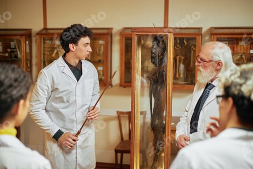 Preview: Young Caucasian Man Explaining Ancient Artifact to Senior Caucasian Man