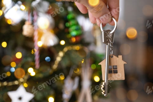 Preview: Key to the house with a keychain is hanging on the Christmas tree. A gift for New Year, Christmas