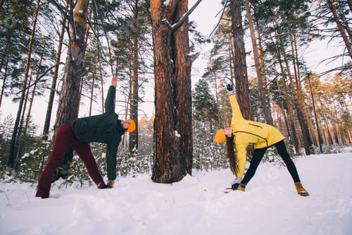Preview: beautiful couple in doing workout or yoga together in winter park