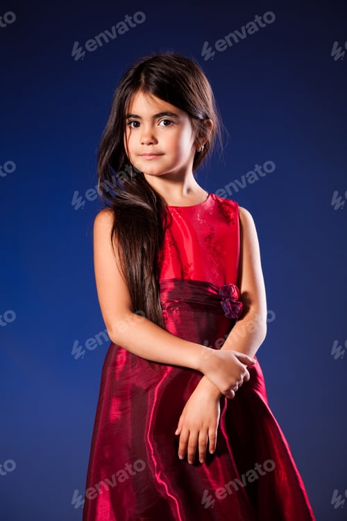Preview: Small girl with long hair in golden red dress over grey background
