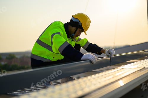 Preview: Worker with safety helmet checking and operating system at solar cell farm