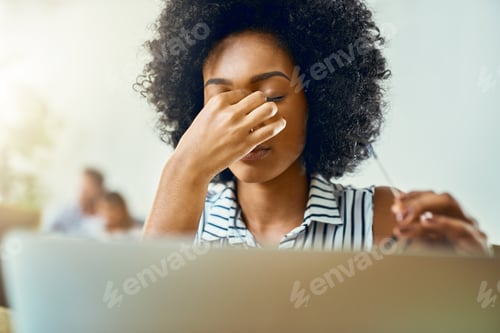 Preview: Cropped shot of a young female designer experiencing a headache in a modern office