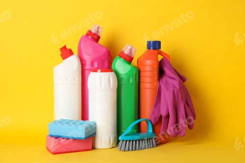 Preview: Bottles with detergent and cleaning supplies on yellow background, space for text