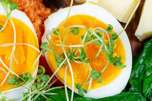 Preview: Closeup shot of boiled eggs and some vegetables and cheese on a wooden surface