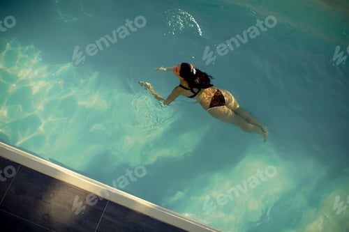 Preview: Aerial view of swimming woman floating in swimming pool