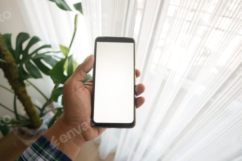 Preview: holding smart phone with white screen inside of a home