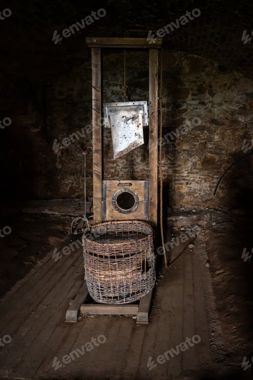 Preview: Working historic Guillotine made from wood and blade located in a dark cellar