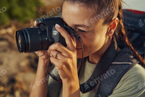 Preview: Woman focusing her camera while making photograph