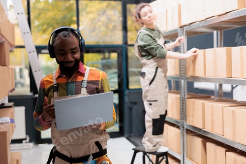 Preview: Storage room employee listening music at headset