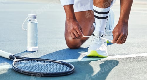 Preview: Cropped shot of an unrecognisable man kneeling down to tie his shoelaces before tennis practice