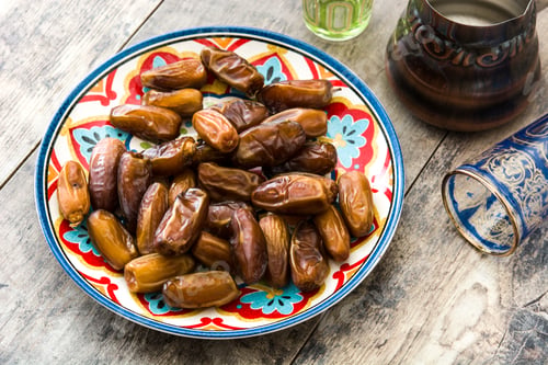 Preview: Delicious dried dates served on a colorful plate with traditional middle eastern drinks