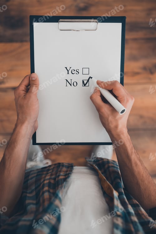 Preview: It is no. Top view of man making a check mark in clipboard while standing on the wooden floor
