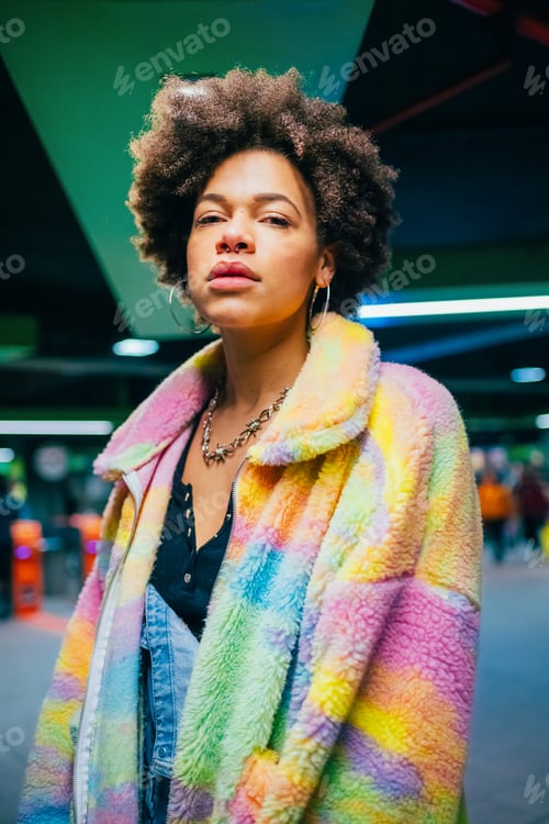 Preview: Portrait young black woman curly hair posing indor metro station cool confident