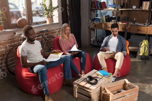 Preview: multiethnic students with books studying together at home