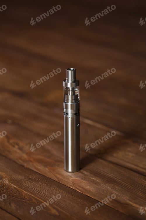 Preview: Electronic cigarette on a wooden table. Smoke