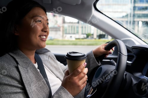 Preview: Chinese woman driving a car and holding a cup of coffee