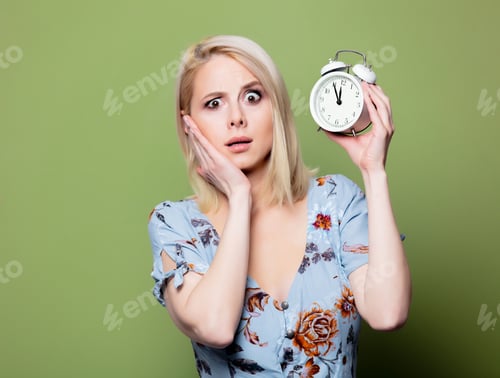 Preview: Blonde woman with alarm clock on green background