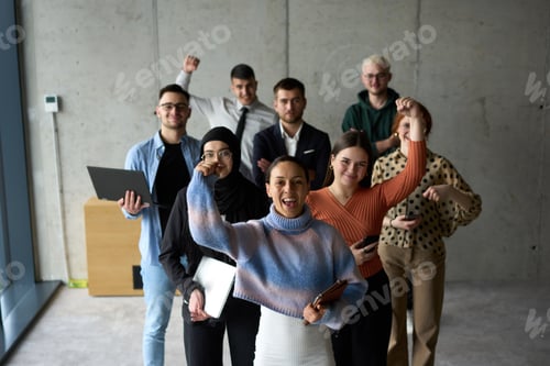 Preview: A diverse team of business professionals ecstatically celebrating their success in a modern office