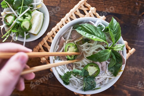 Preview: vietnamese pho with beef being eaten with chopsticks