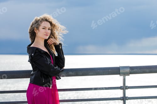 Preview: A woman stands on a bridge against the background of a gloomy sky