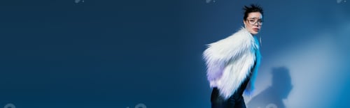 Preview: trendy woman in stylish faux fur jacket and transparent sunglasses on blue background with copy
