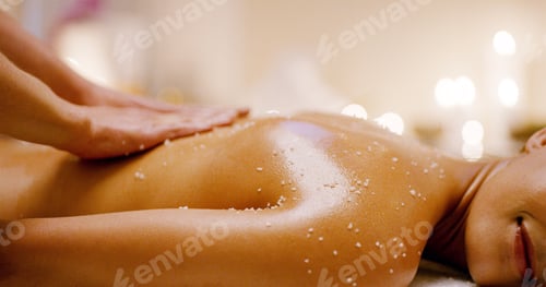 Preview: Hands, back massage and woman with oil, exfoliating and holistic spa center for wellness and zen. M