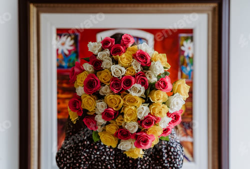 Preview: Portrait without face. Girl hiding face behind bright colorful roses flowers bouquet