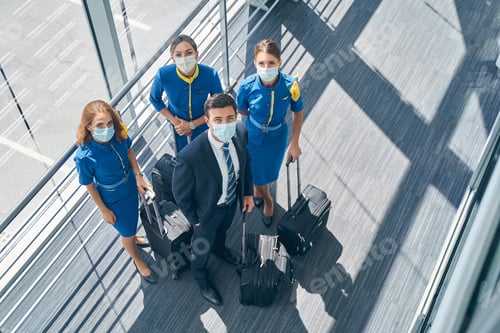 Preview: Four flight attendants in masks looking up
